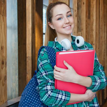 Aphoto of a teenage schoolgirl, carrying a folder.