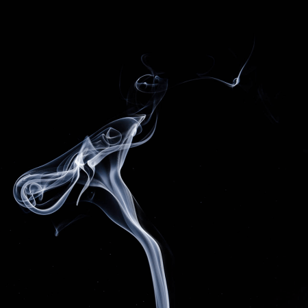 photo of cigarette smoke in a darkened room.
