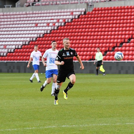 Photo of a professional soccer match being played in an empty stadium.