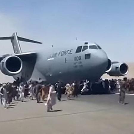 Image of a US airplane attemptingto evacuate from Kabul. It is surrounded by Afghabns wanting to flee.