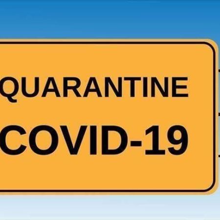 A yellow/black Covid Quarantine sign.